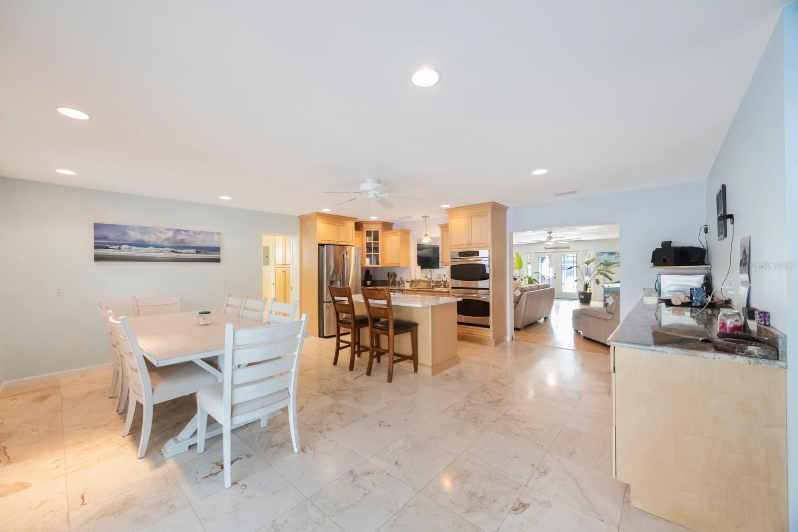 Imagine hosting friends and family in this expansive dining and kitchen area, the true heart of the home. With its open layout, bright atmosphere, and central kitchen island, it's perfectly suited for casual Florida living and easy entertaining