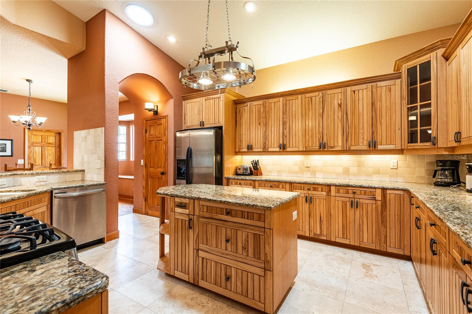 Gas cooking, Island work space, Hickory custom cabinetry and hanging light fixture to hang your pots and pans from.