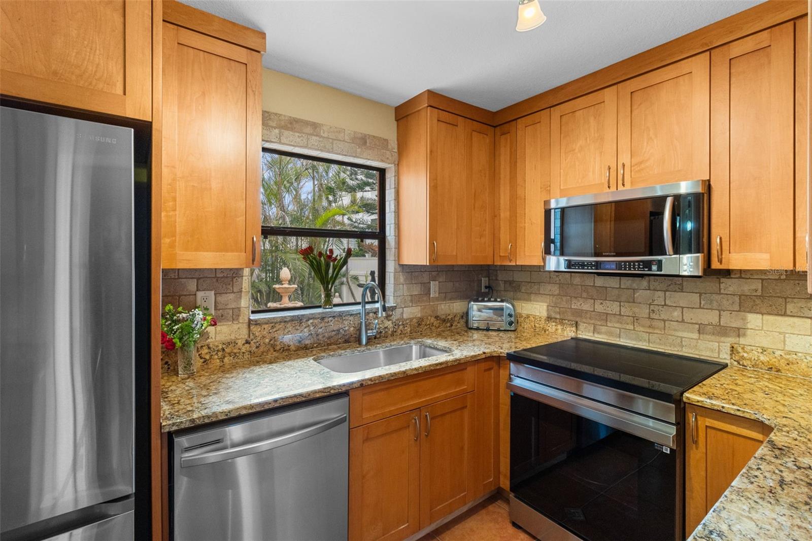 Perfect combonation of style and function in this Gallley kitchen with Matching Stainless Appliances and a Induction cooktop. 819 Gulf Blvd, a charming 2-bedroom, 1-bath ranch-style quaint Bungalow located just steps from beach access on the stunning shores of Indian Rocks Beach, Indian Rocks Beach Nature Preserve with public dog park and a Boardwalk to through the Mangroves on the Intercoastal.