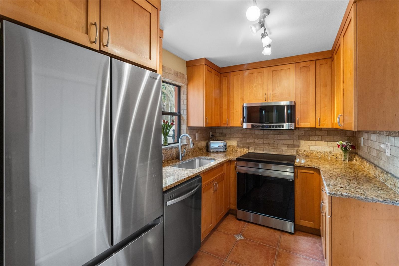 Perfect combonation of style and function in this Gallley kitchen with Matching Stainless Appliances and a Induction cooktop. 819 Gulf Blvd, a charming 2-bedroom, 1-bath ranch-style quaint Bungalow located just steps from beach access on the stunning shores of Indian Rocks Beach, Indian Rocks Beach Nature Preserve with public dog park and a Boardwalk to through the Mangroves on the Intercoastal.