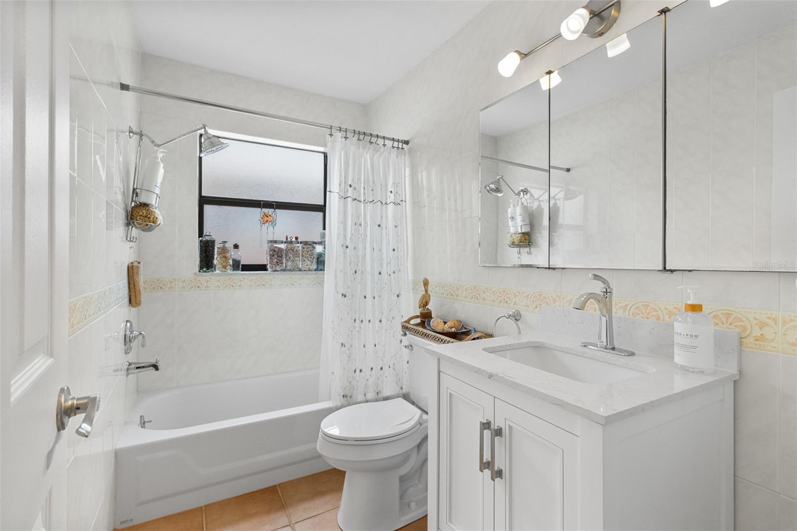 Full Bath with Shower/Tub Combo, tiled walls, and new vanity. 819 Gulf Blvd, a charming 2-bedroom, 1-bath ranch-style quaint Bungalow located just steps from beach access on the stunning shores of Indian Rocks Beach, Indian Rocks Beach Nature Preserve with public dog park and a Boardwalk to through the Mangroves on the Intercoastal.