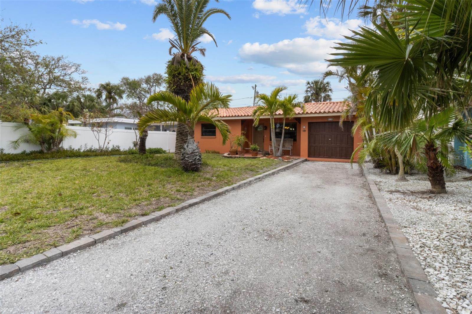 Instant Curb Appeal with Christmas Palms, Grass with reclaimed water sprinkler system, and newly poured shell driveway.  819 Gulf Blvd, a charming 2-bedroom, 1-bath ranch-style quaint Bungalow located just steps from beach access on the stunning shores of Indian Rocks Beach, Indian Rocks Beach Nature Preserve with public dog park and a Boardwalk to through the Mangroves on the Intercoastal.