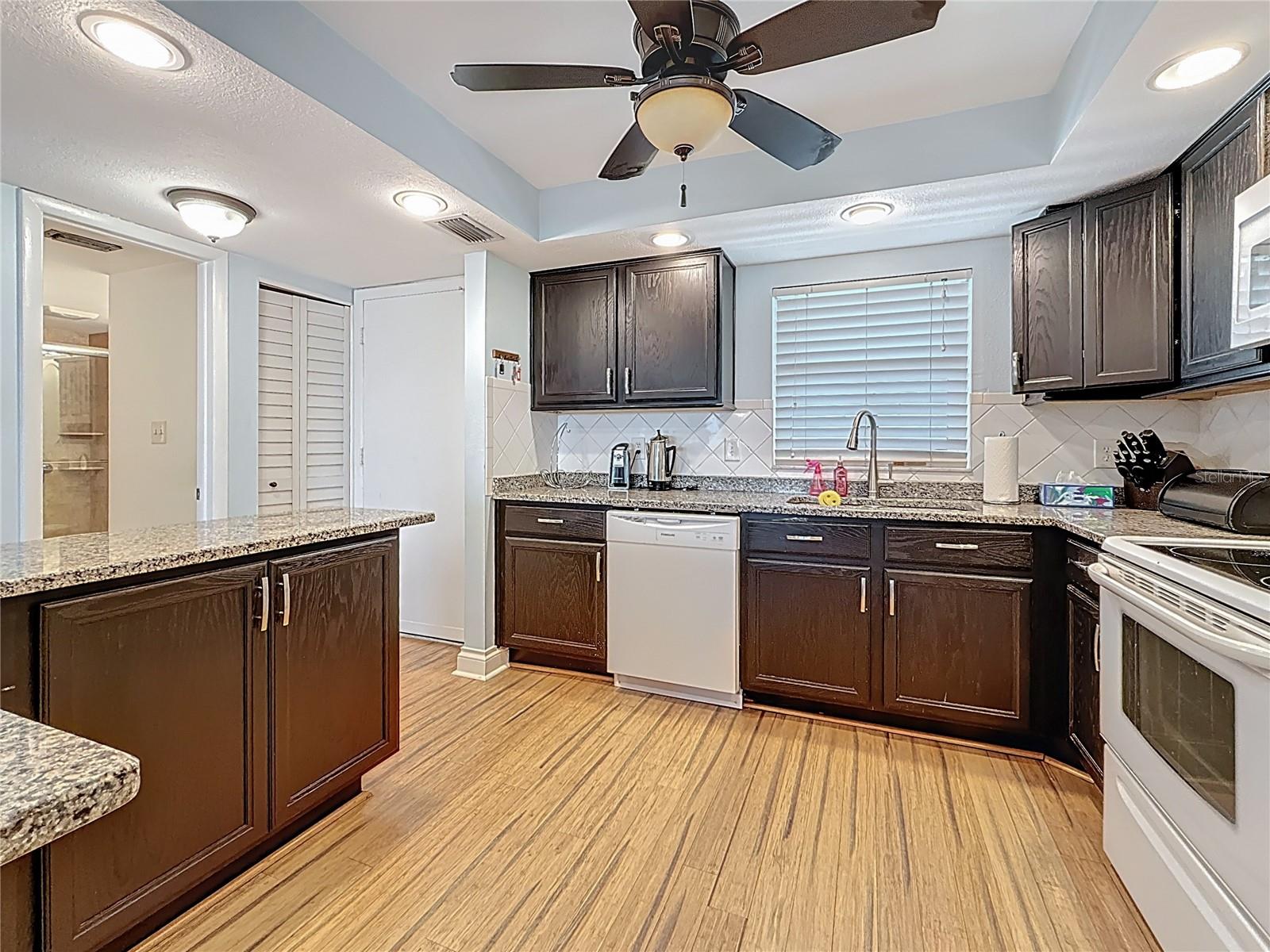This view shows the open kitchen plan and the extra cabinet space and counter space that this kitchen has