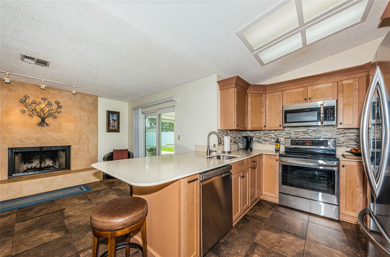 Kitchen with stainless steel appliances and large breakfast bar