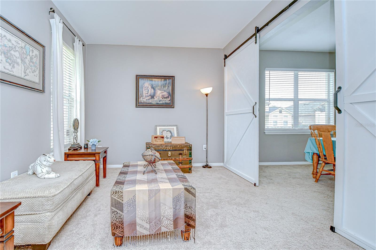 The formal living and dining rooms are separated by white sliding barn doors, offering charm and flexibility!