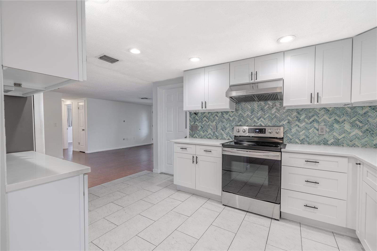 This stunning kitchen blends modern style with everyday functionality. Bright shaker-style cabinetry provides generous storage and clean, timeless appeal, beautifully complemented by sleek quartz countertops.