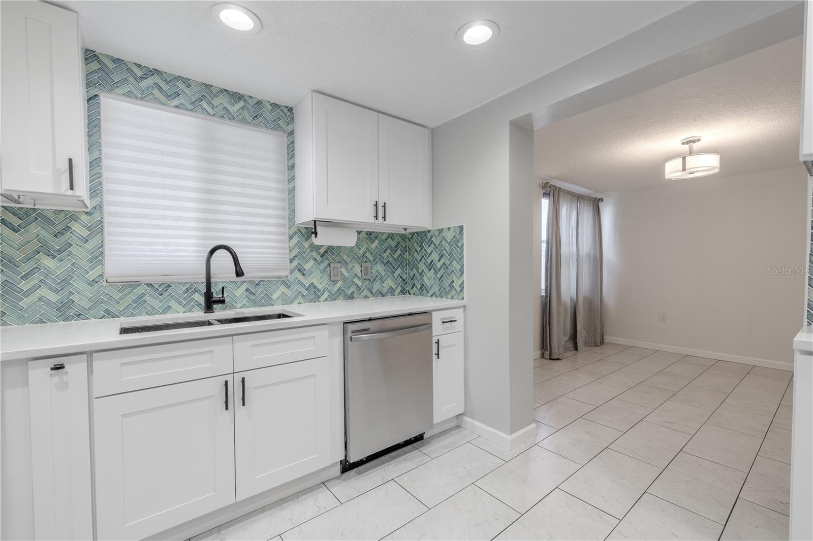 Just off the kitchen, you'll find a bright and versatile dining area with sleek tile flooring and soft-toned walls that reflect natural light throughout the day.