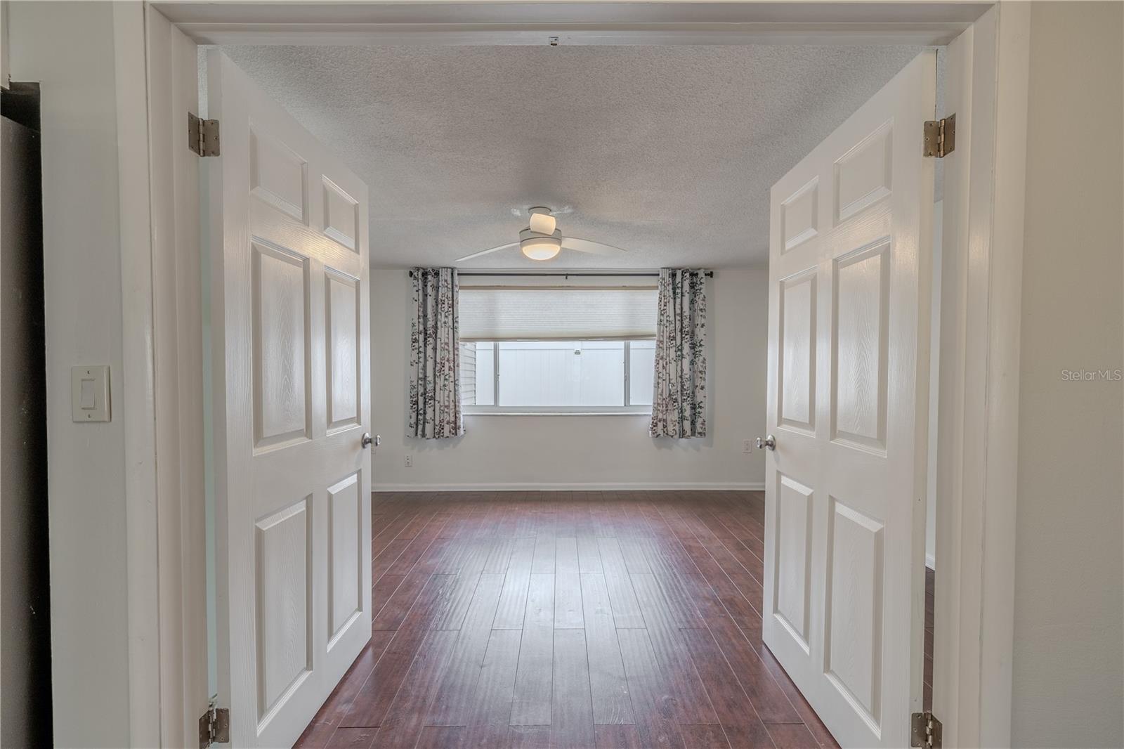 Double doors open to a spacious bonus room that offers endless possibilities—whether you're looking for a home office, guest room, playroom, or cozy den. With wide plank flooring and soft, neutral walls, the space feels both warm and adaptable.Just off the main living area and kitchen, this bonus room is perfectly positioned to be part of the action while still offering a sense of privacy—ideal for work, hobbies, or relaxation.