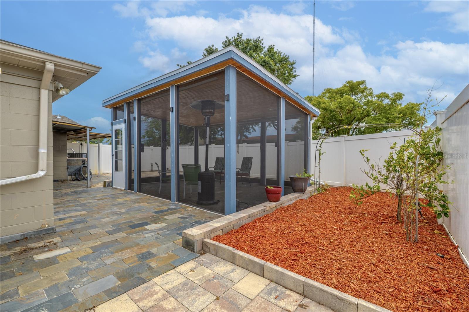 The adjacent garden bed and surrounding patio add charm and low-maintenance appeal, while the clean lines and quality finishes make this a standout feature of the home.