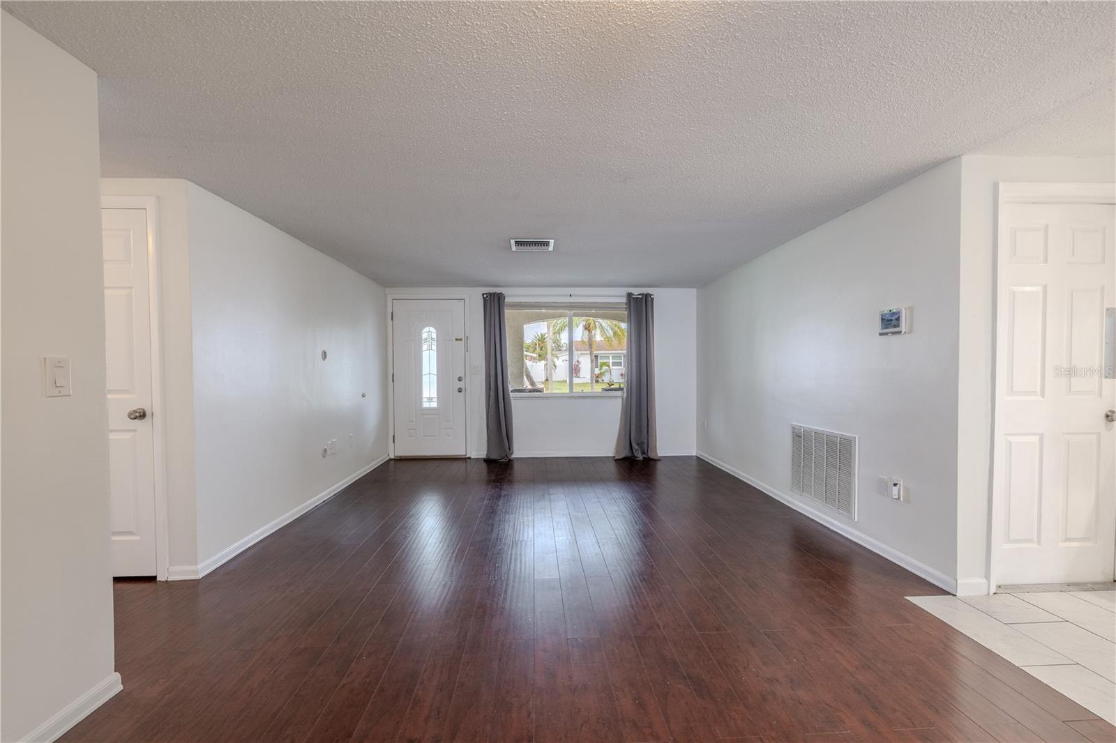 Just off the entryway, the room offers an ideal setup for a cozy sitting area or an expansive media wall, making it the perfect spot to unwind, entertain, or simply enjoy the comforts of home.