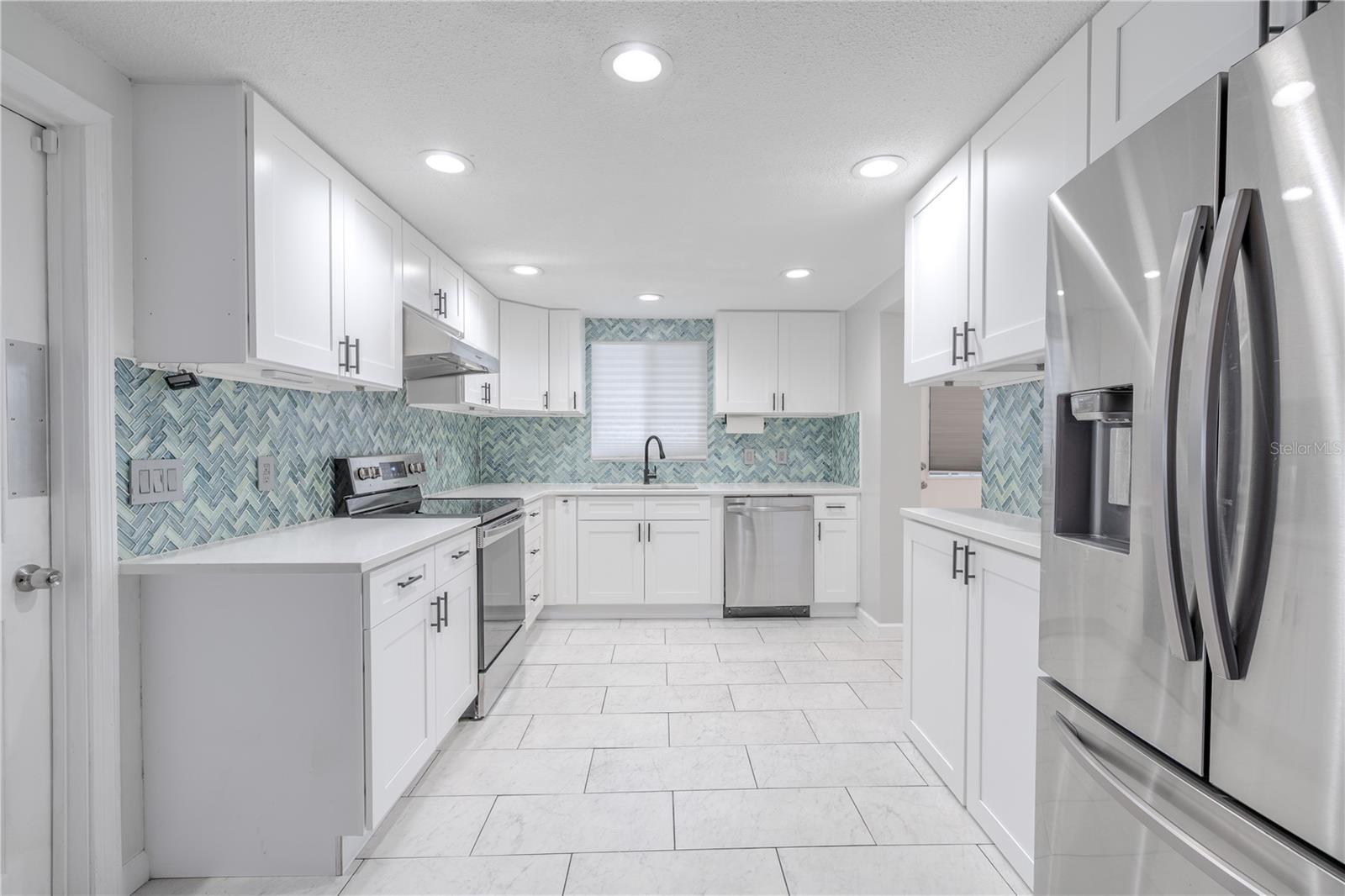 This stunning kitchen blends modern style with everyday functionality. Bright shaker-style cabinetry provides generous storage and clean, timeless appeal, beautifully complemented by sleek quartz countertops.