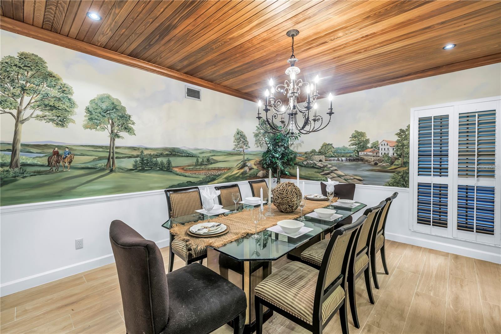 Grand Dining Space with hand painted mural by a local artist.  Wood panel ceiling and lighting are gorgeous