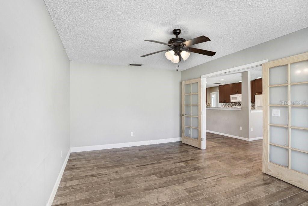 Office with sliding doors that open to the living room, kitchen and dining area