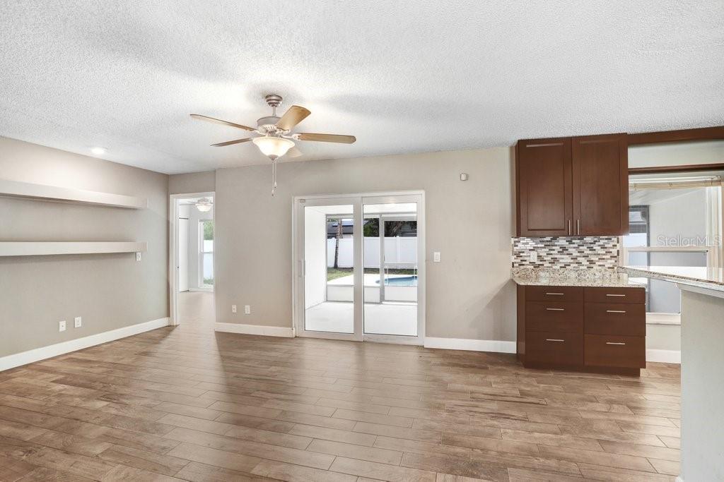 Living room with view to the lanai and pool area and open to the kitchen and dining area