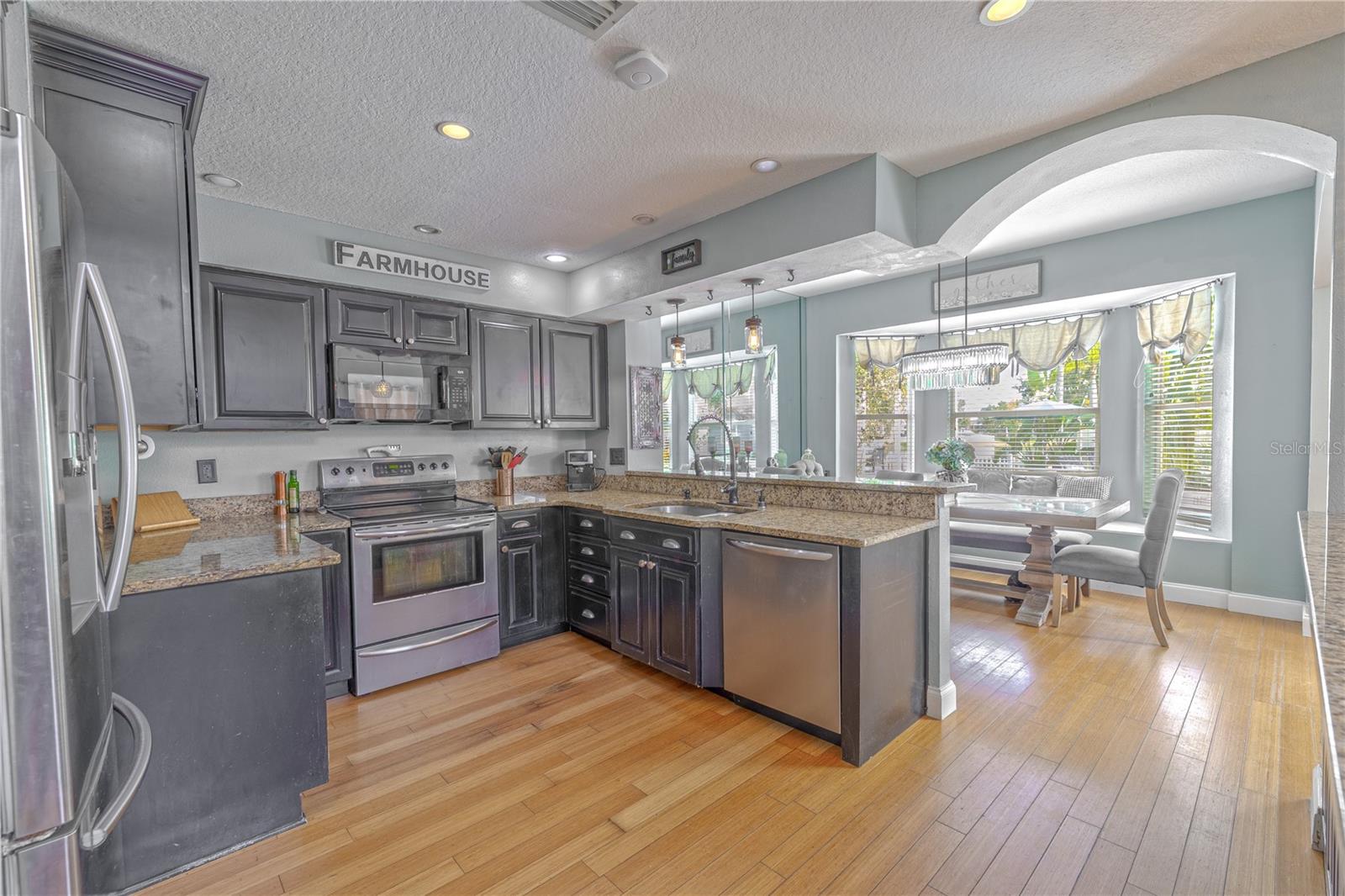 A full suite of stainless steel appliances is complemented by a dual-basin under-mount sink and gooseneck faucet with pull-down sprayer.