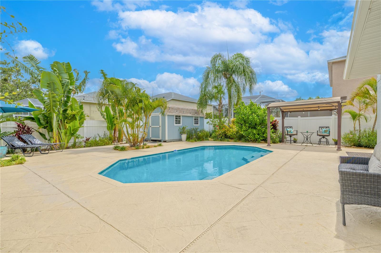 Your own private paradise with a beautifully maintained in-ground pool as the centerpiece of the fully fenced backyard. Surrounded by tropical landscaping and mature palms, the pool area offers a serene escape with plenty of space for lounging, entertaining, or enjoying the Florida sunshine.