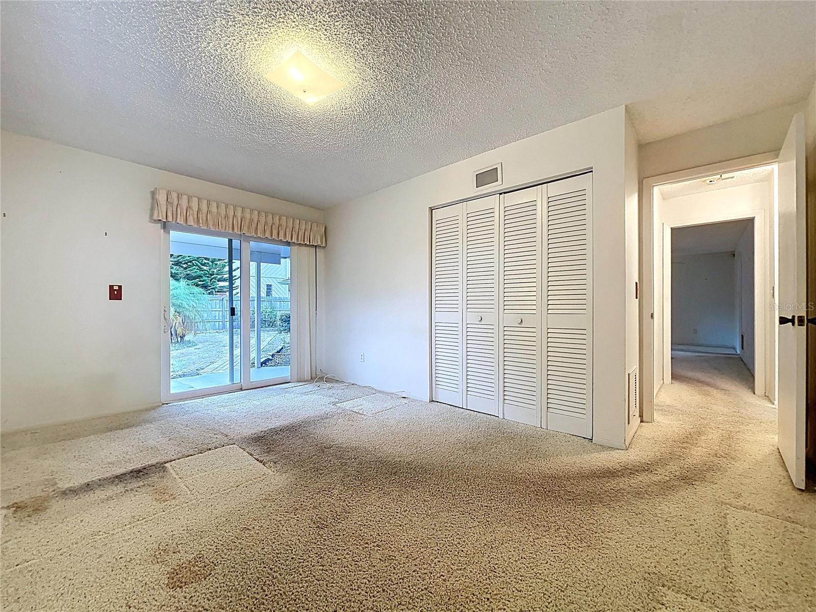 2nd bedroom with double pane windows and sliding glass door onto rear patio.