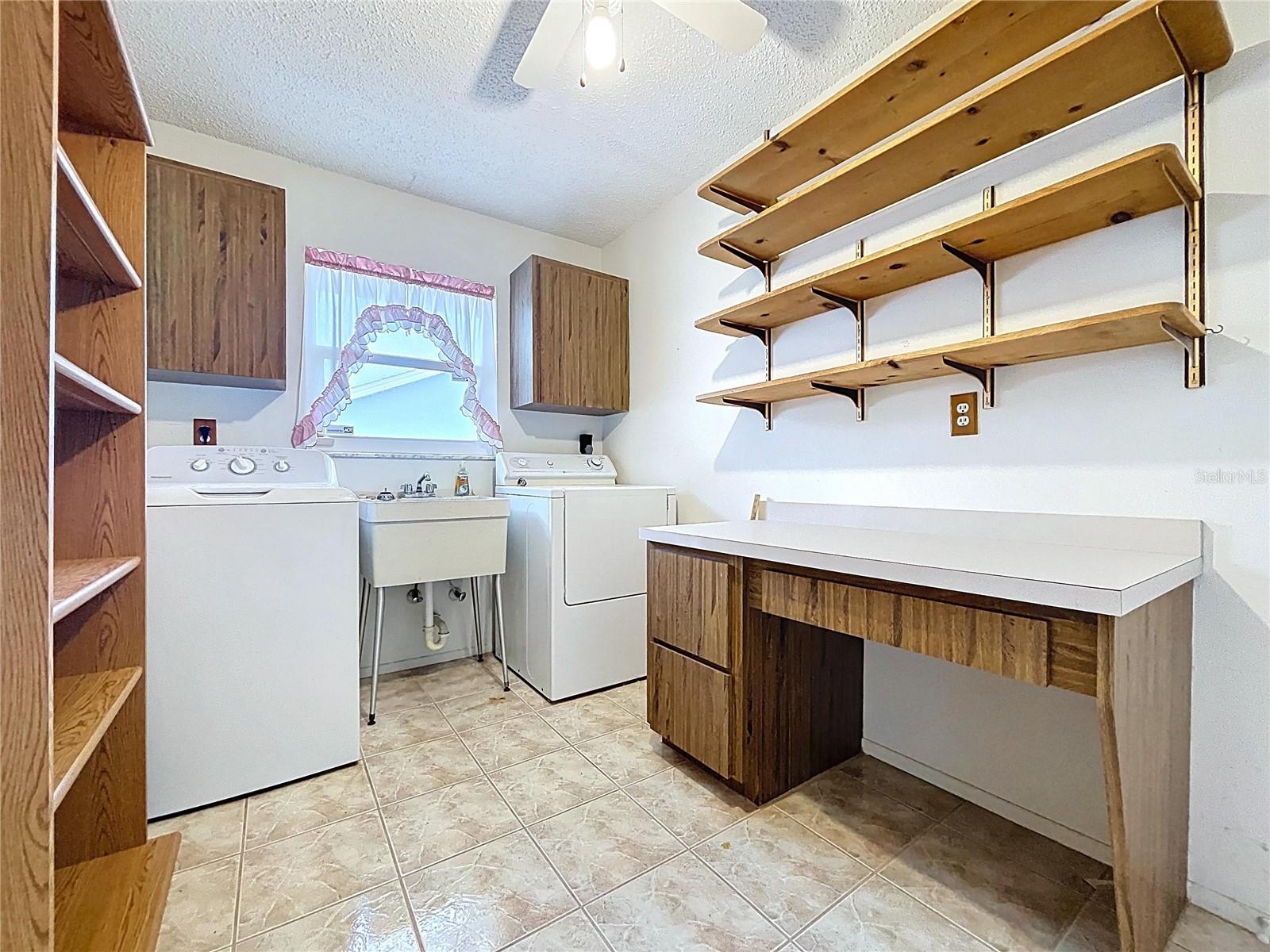 Inside utility room offers laundry hookups and utility sink.