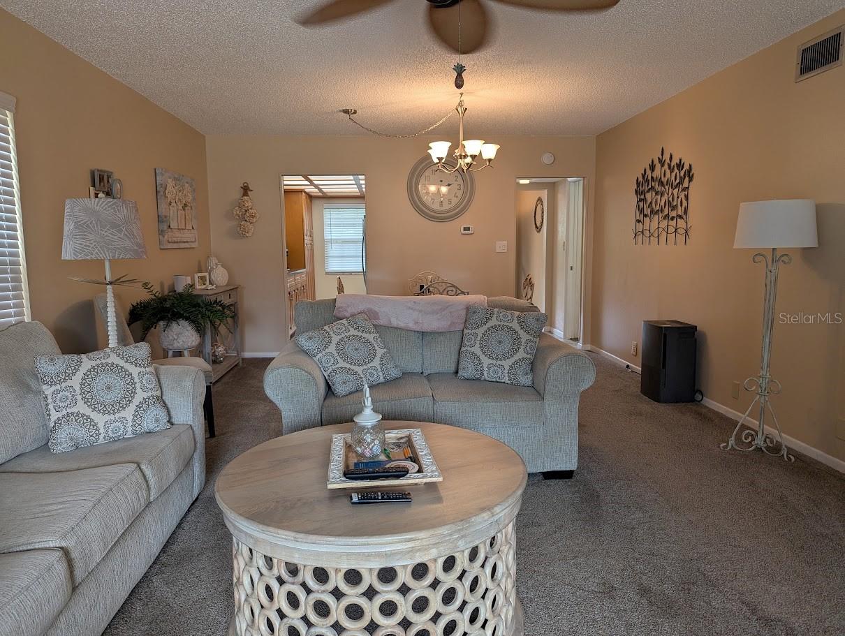 Living dining space with view to kitchen and entry foyer