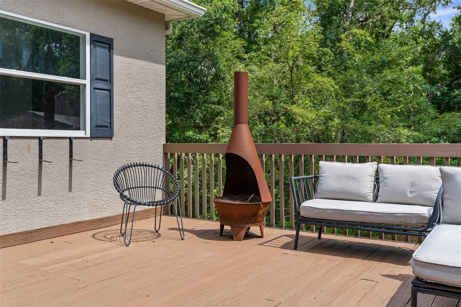Heated pool and jacuzzi with paver deck and iron fence.