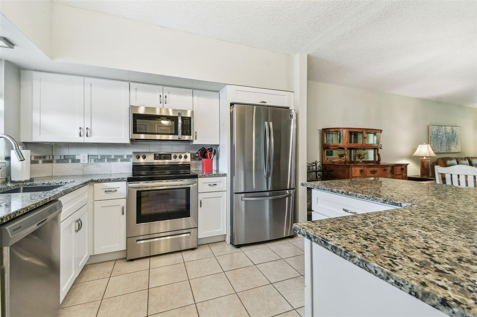 Lovely updated Kitchen with granite counters, soft close cabinets and drawers, stainless appliances