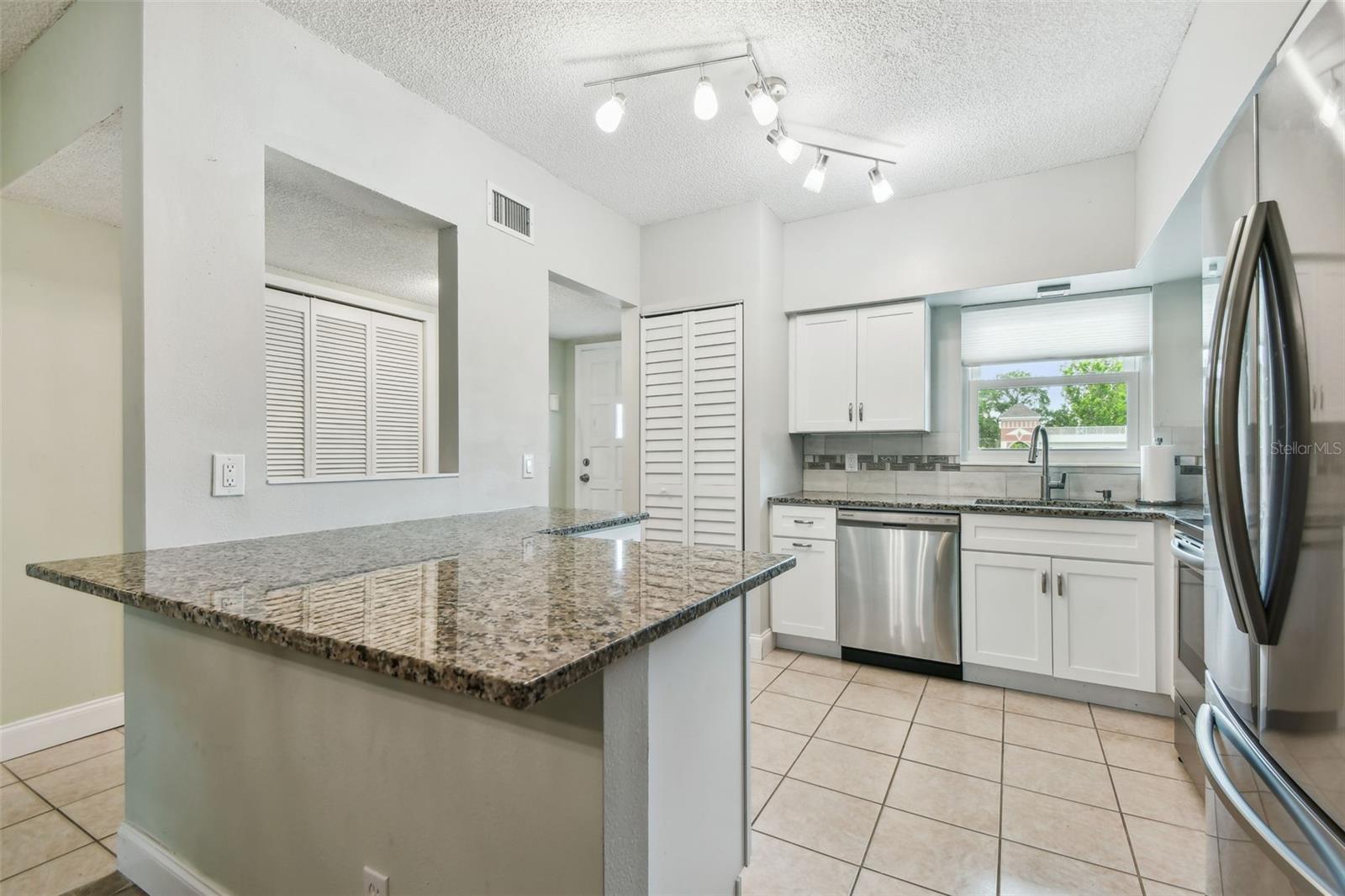 Nice snack bar. Kitchen open to the living spaces for more sociability. Stackable washer/dryer in louvered closet.
