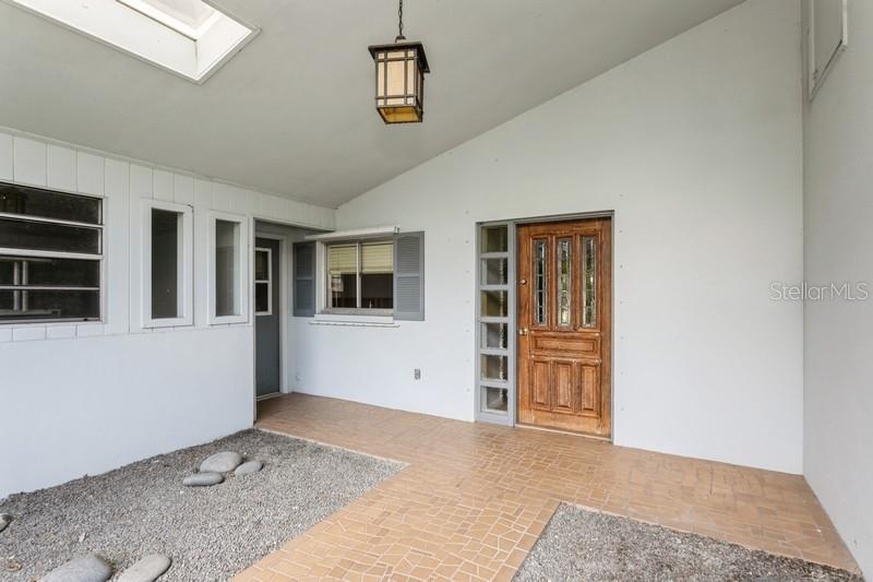 Porch area with front house door and garage door to the left