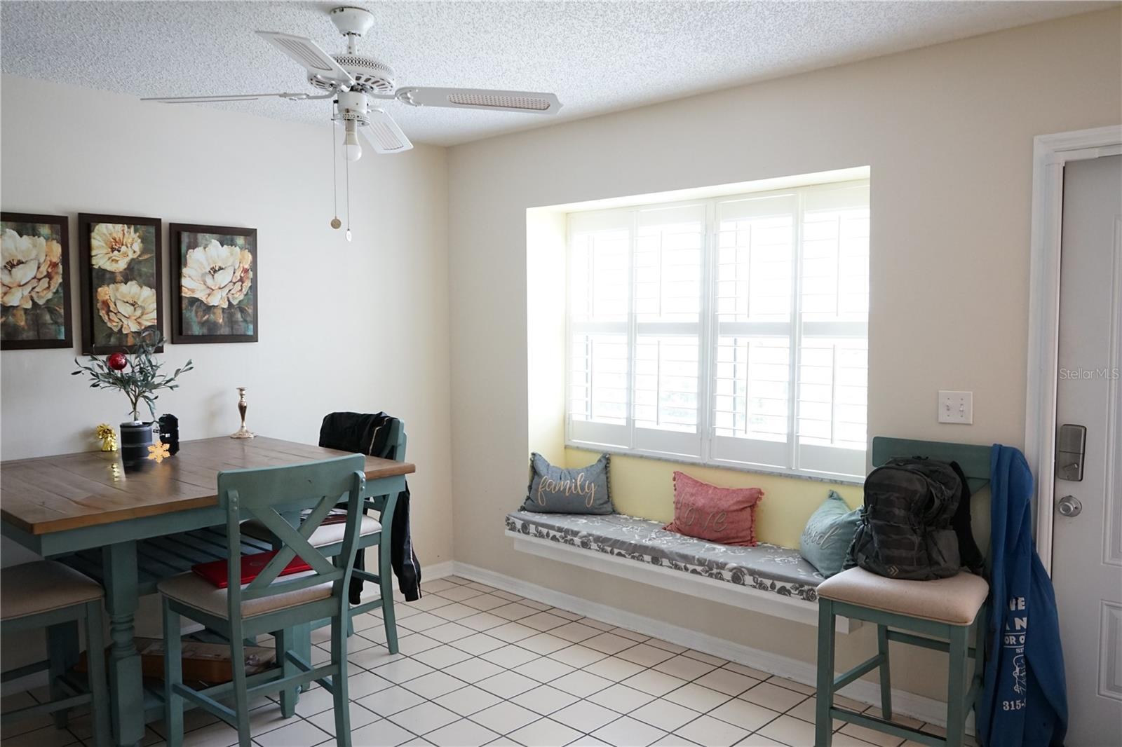 dining window has a seat and plantation style shutters