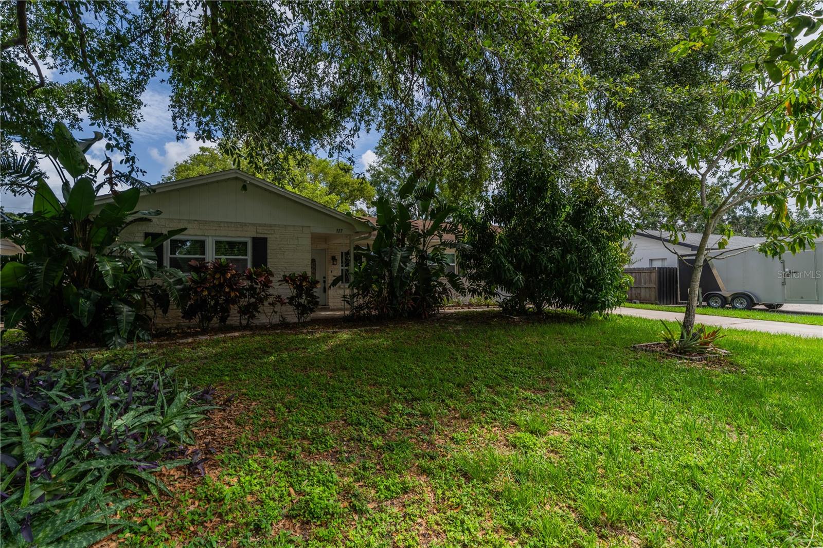 Front of home with lush vegetation