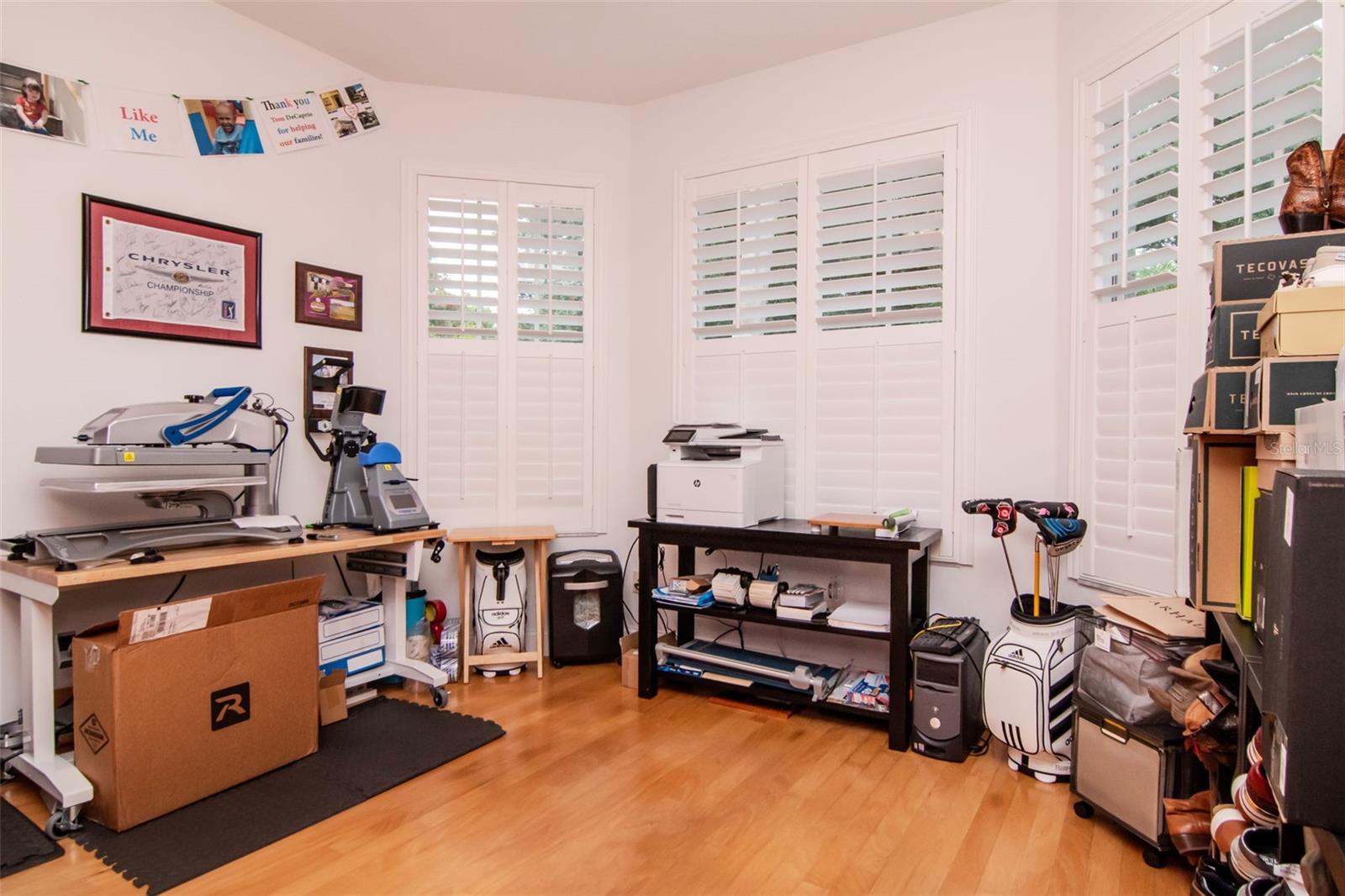 Large office / Den with an abundance of windows and shutters.
