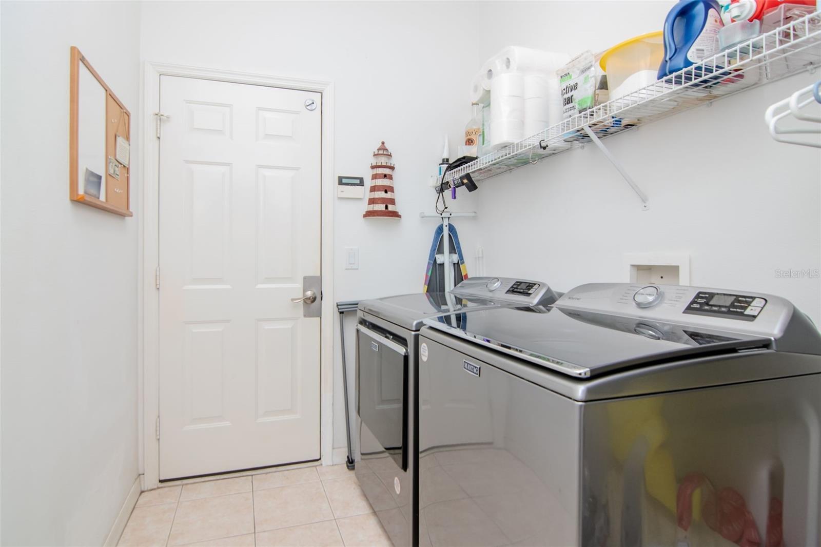 Laundry Room that leads to the garage. Washer and dryer stay!