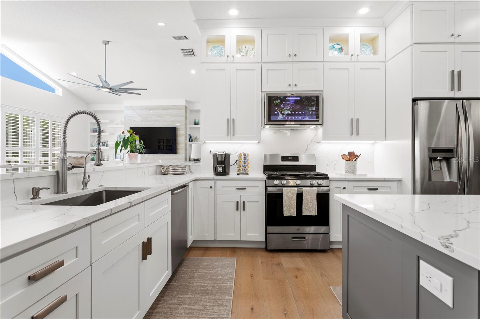This gorgeous kitchen blends elegance with innovation, featuring a GE Kitchen Hub - a smart display range hood that gives you access to your favorite apps, recipes, and entertainment while you cook.