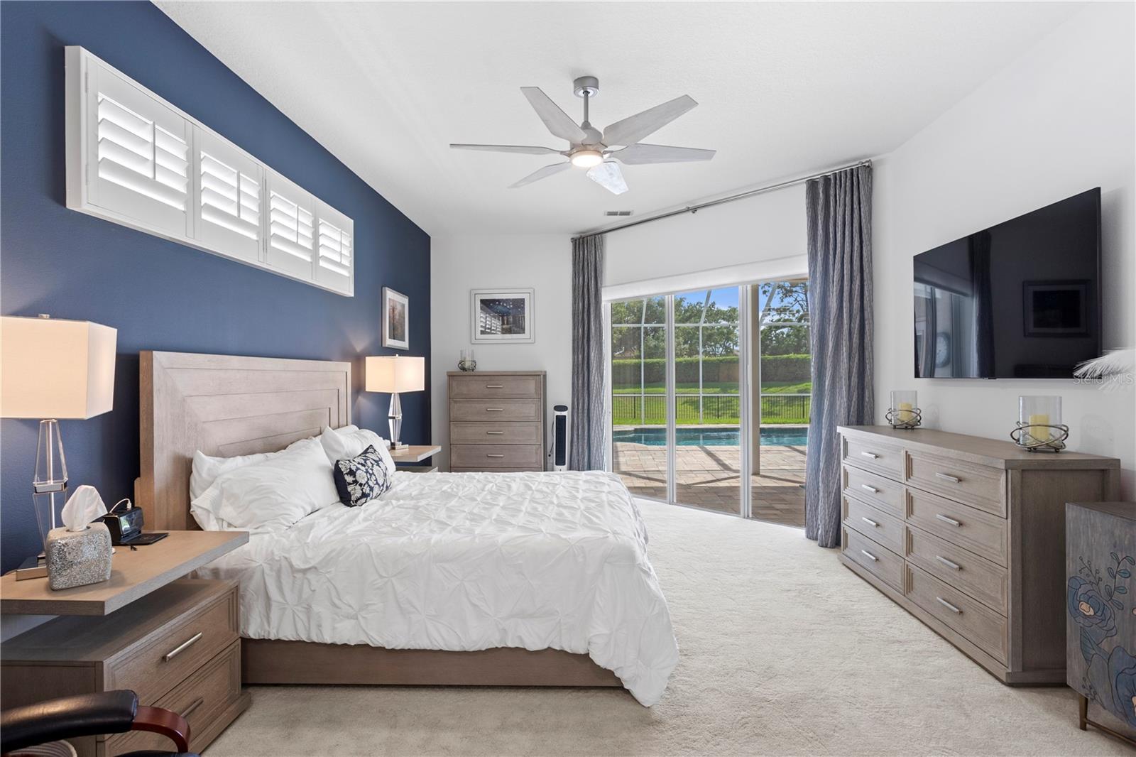 Sliding glass doors provide private access from the primary bedroom to the covered lanai and pool - perfect for a morning swim or evening unwind.