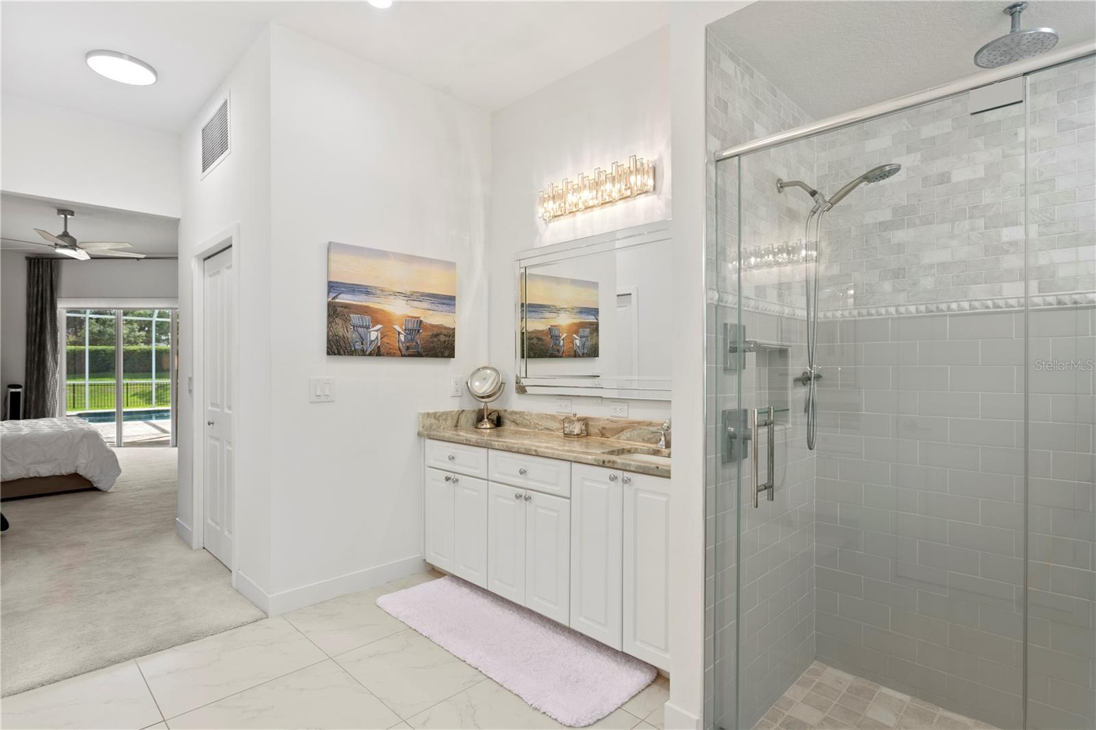 This beautifully appointed primary bath features a large walk-in shower and dual vanities.