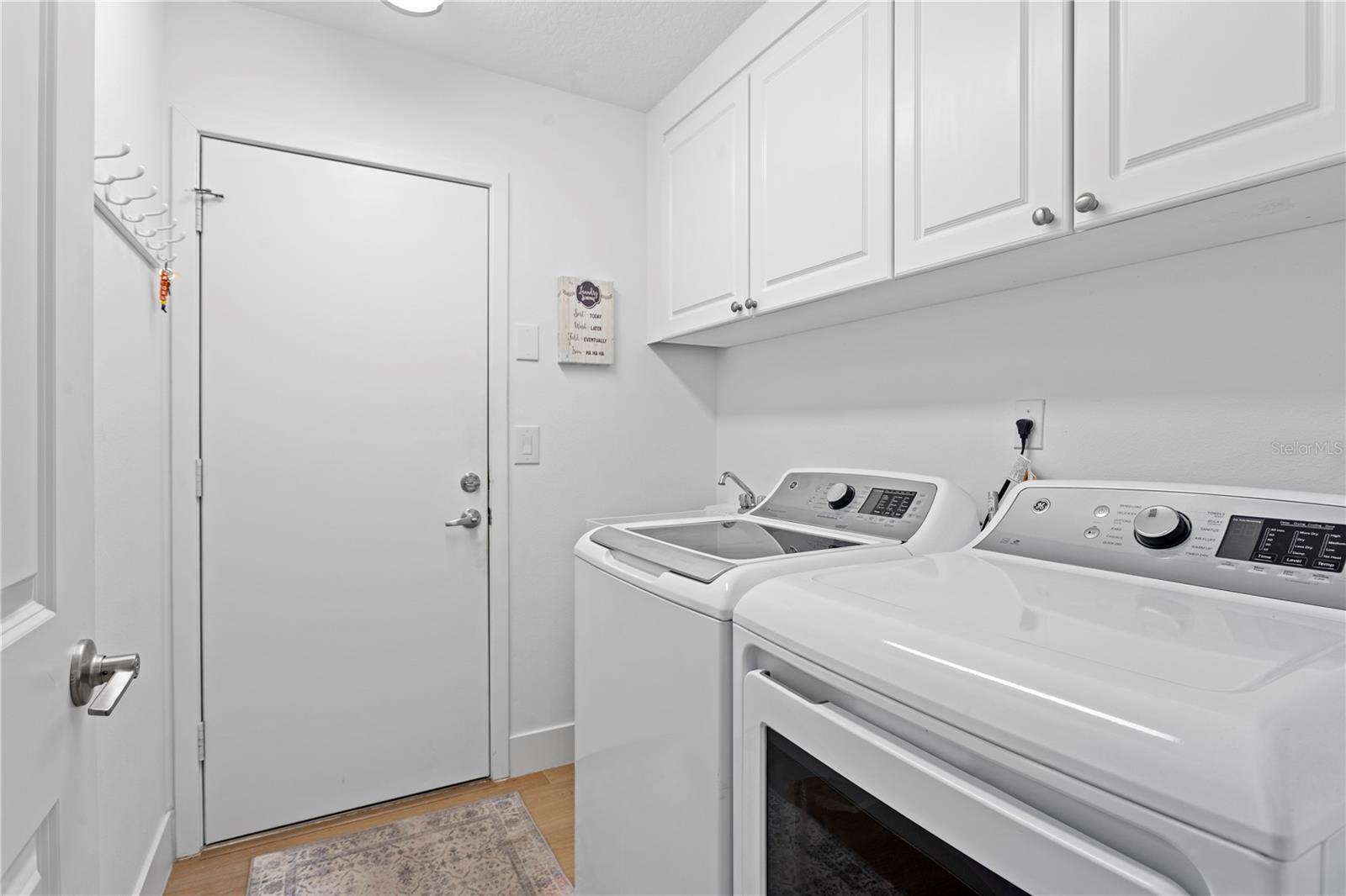 Conveniently located just off the garage, this laundry room features cabinet storage and a handy utility sink.