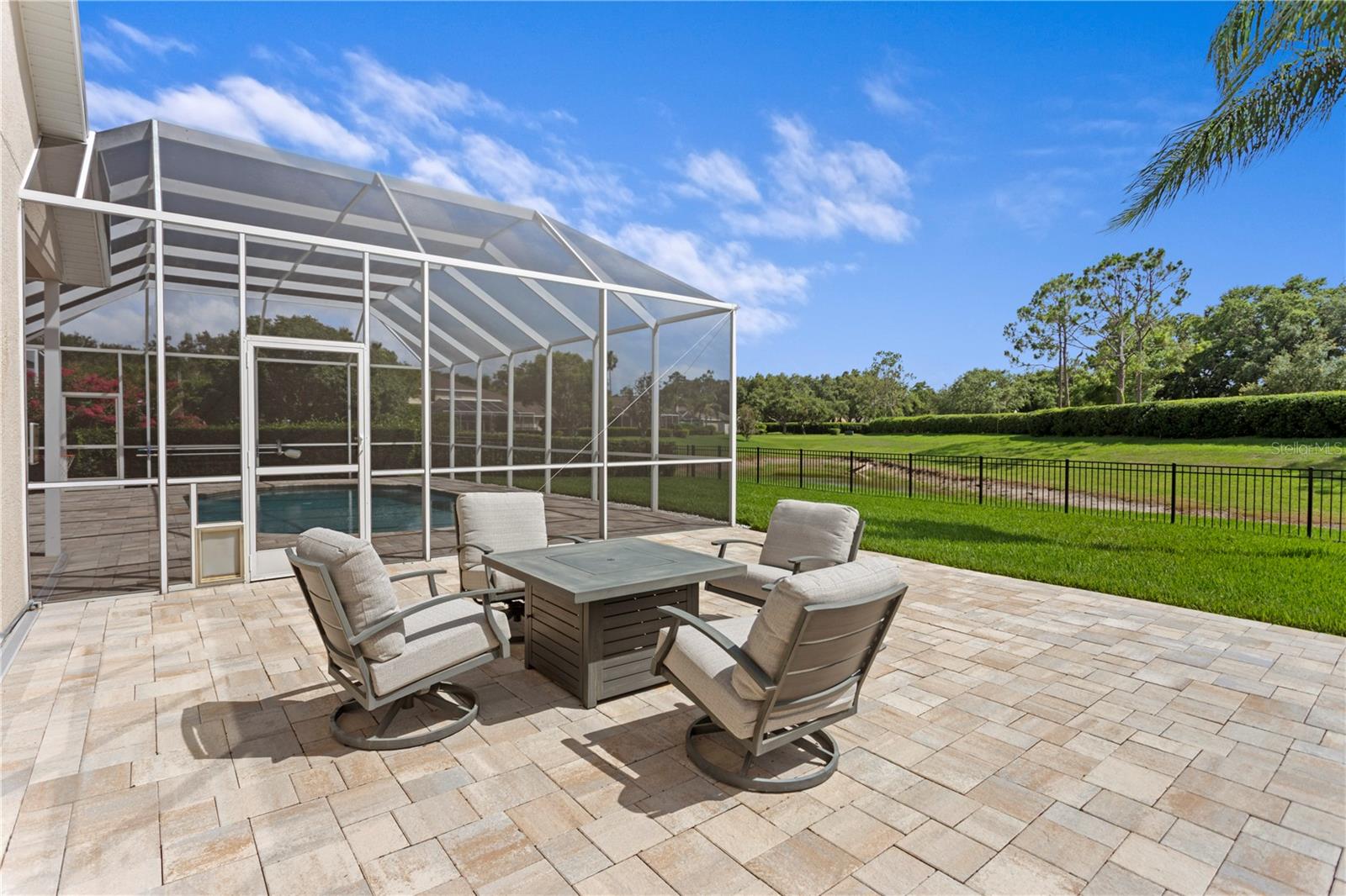 Extend your living space outdoors with this stunning brick paver area, ideal for entertaining or unwinding by a fire pit.