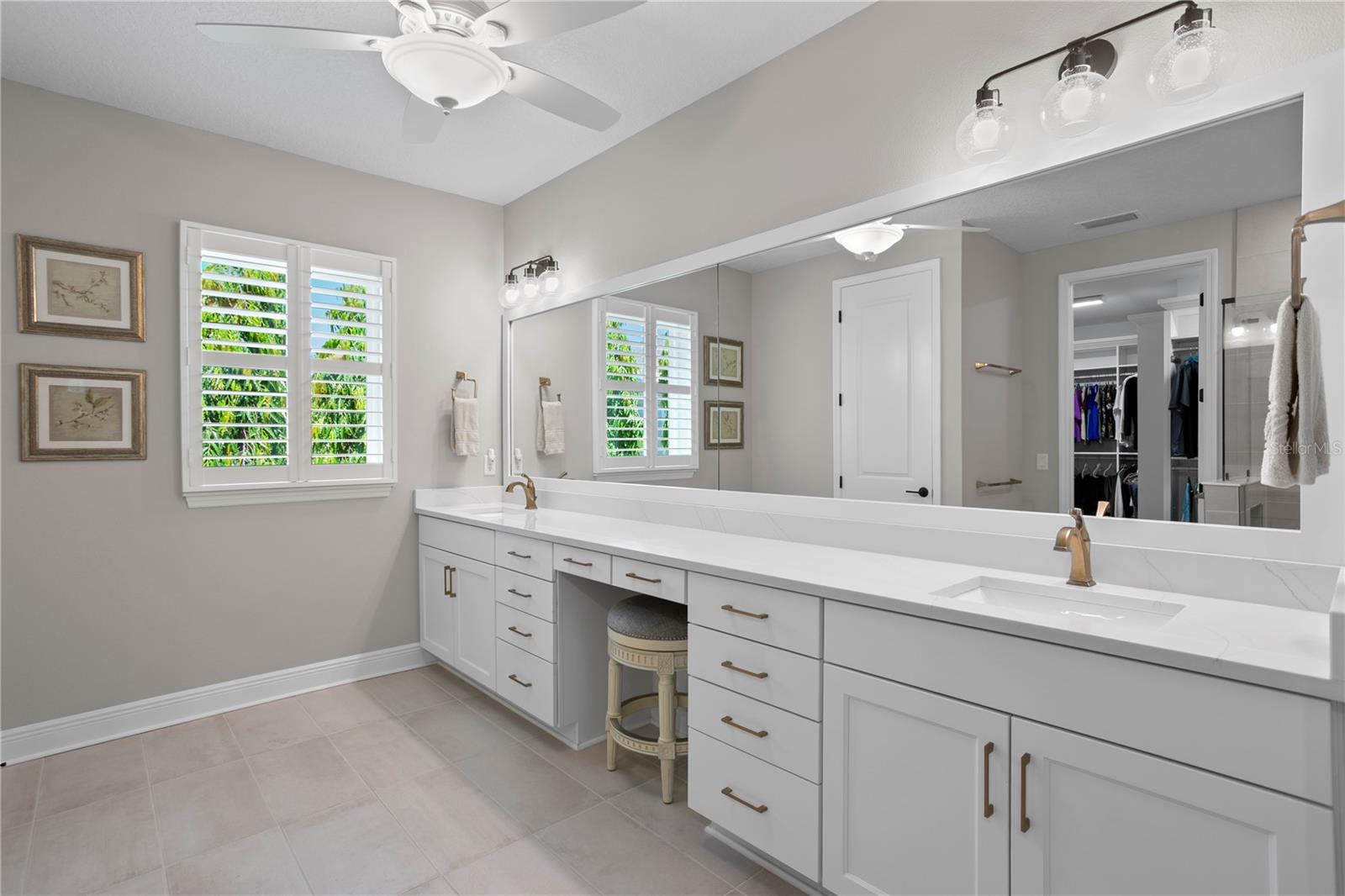 The primary bath features a large double vanity with tons of storage and a spot to sit and get ready.