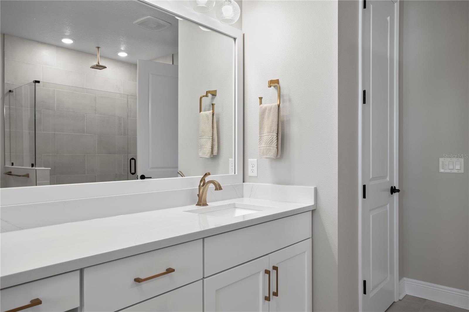 Elegant and functional, this bathroom also features a large linen closet.