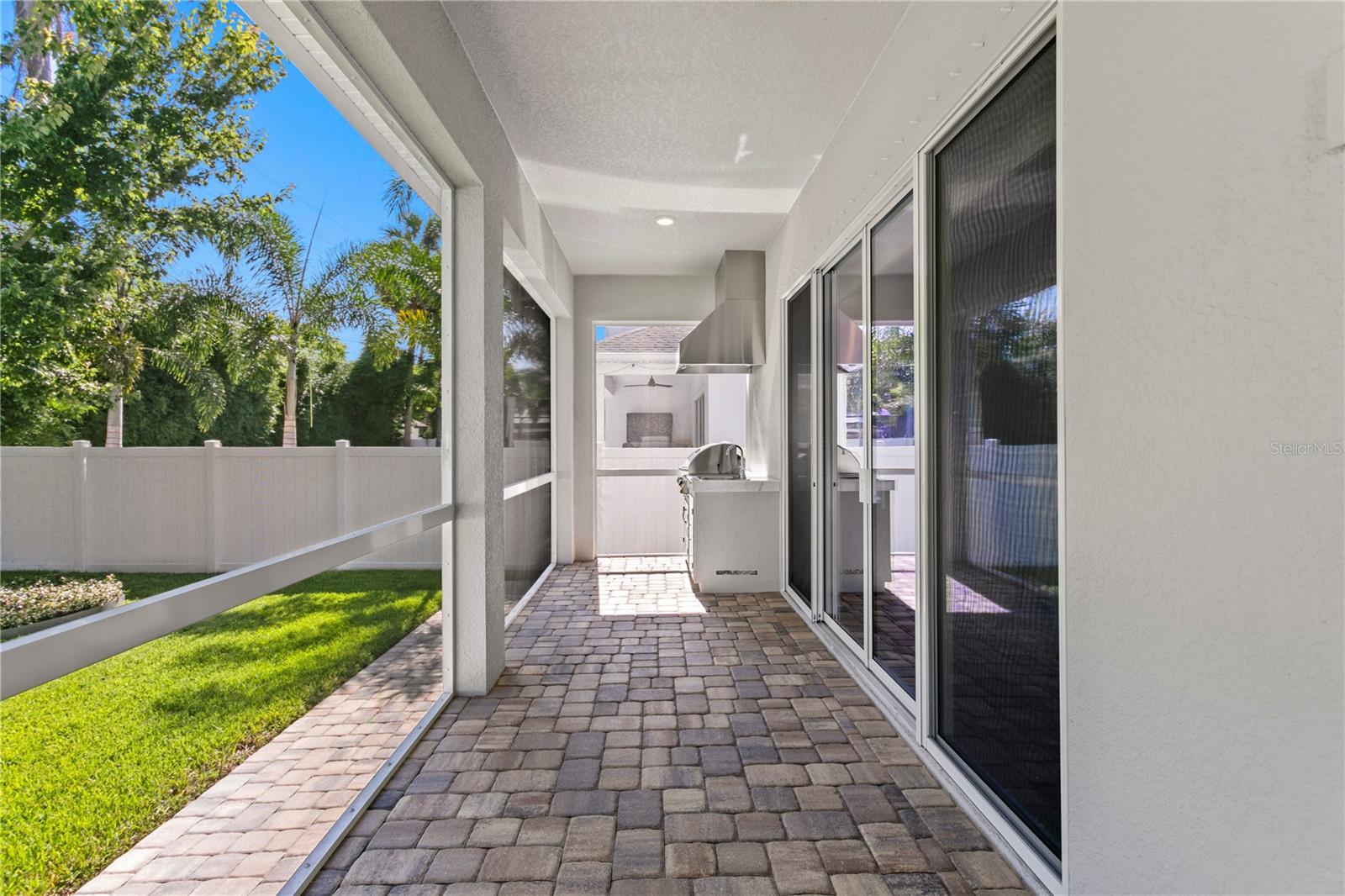 This perfect covered and screened back porch features a built-in gas grill and prep sink.