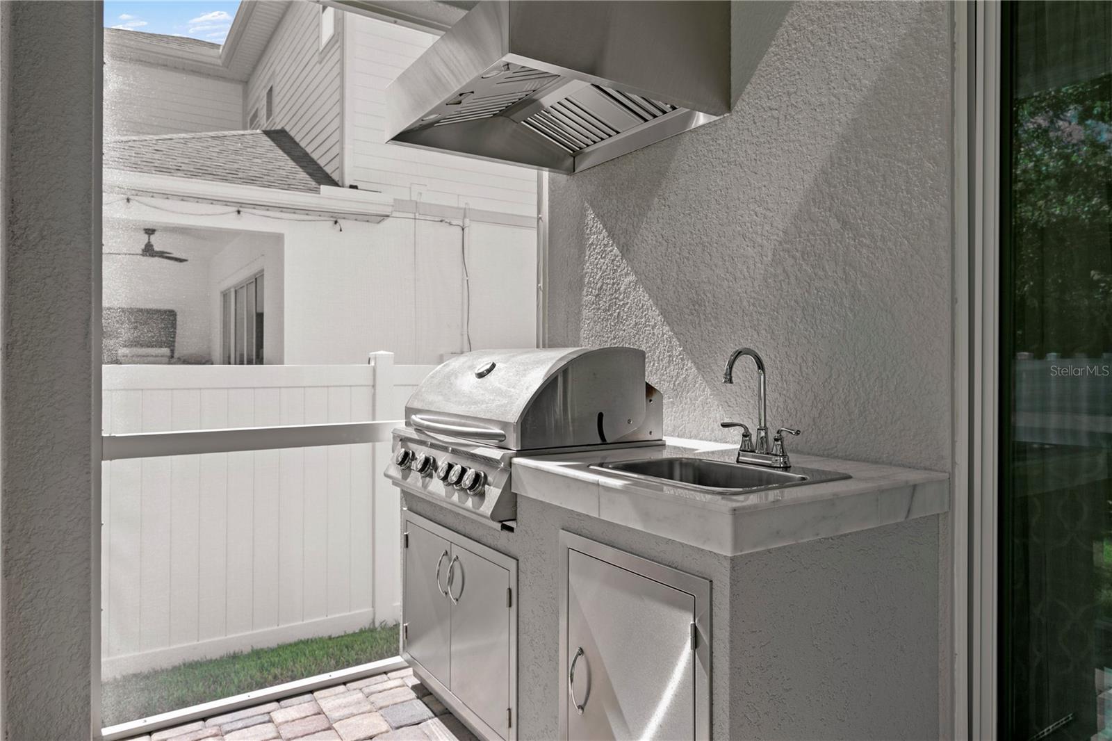 The grill is connected to natural gas. The commercial vent hood, prep sink and storage make grilling out super easy.