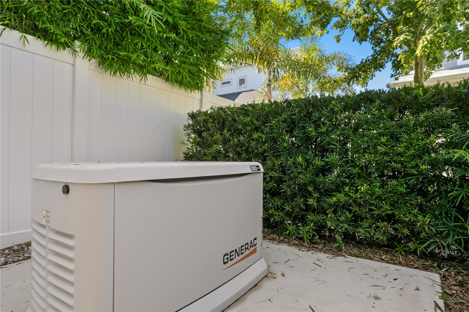 The whole-house Generac generator is discreetly tucked behind mature landscaping in the back corner of the backyard, offering peace of mind without disrupting the natural beauty of the space.