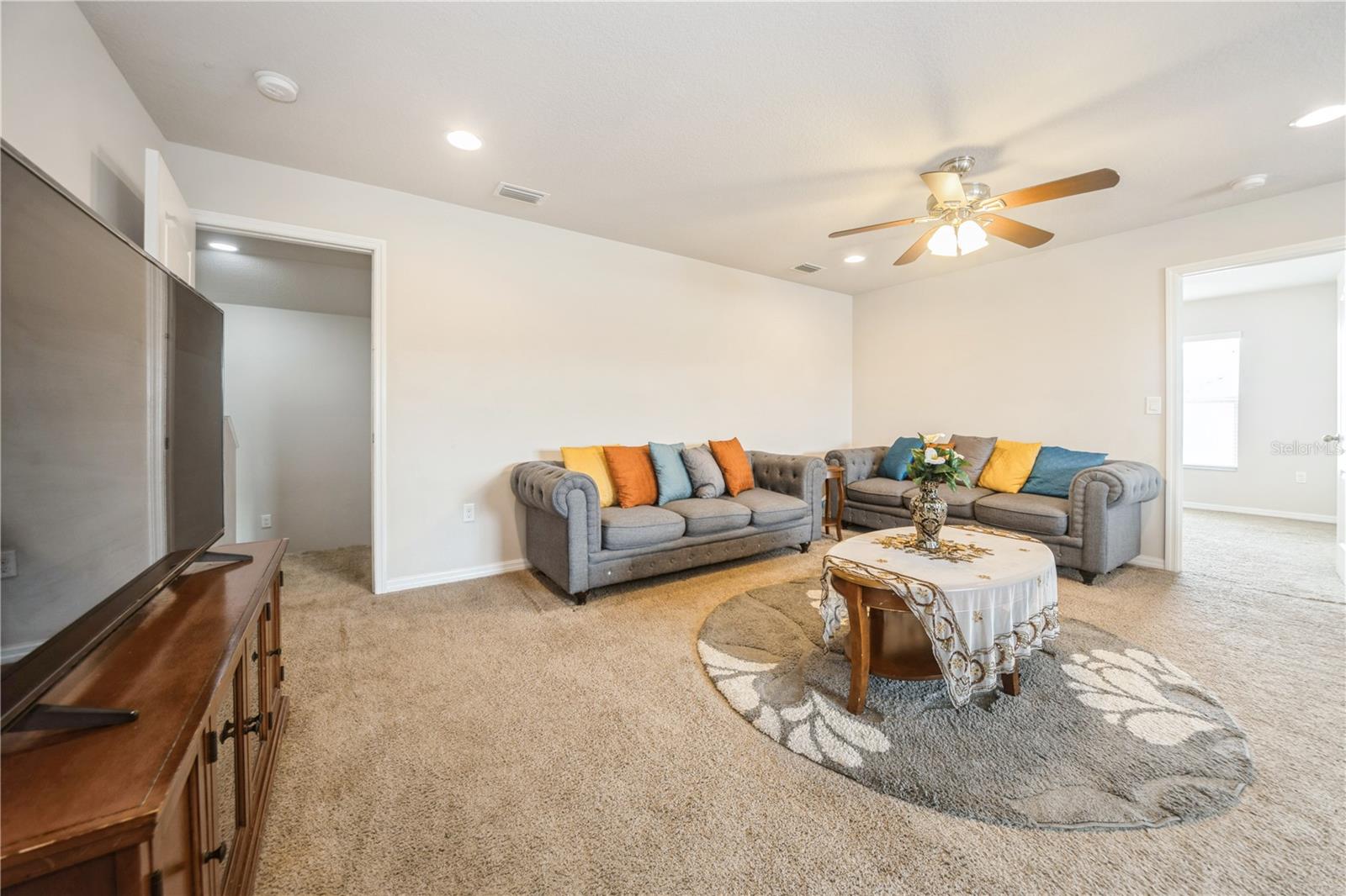 Bright and versatile loft with recessed lighting and ample room for relaxation or entertainment.