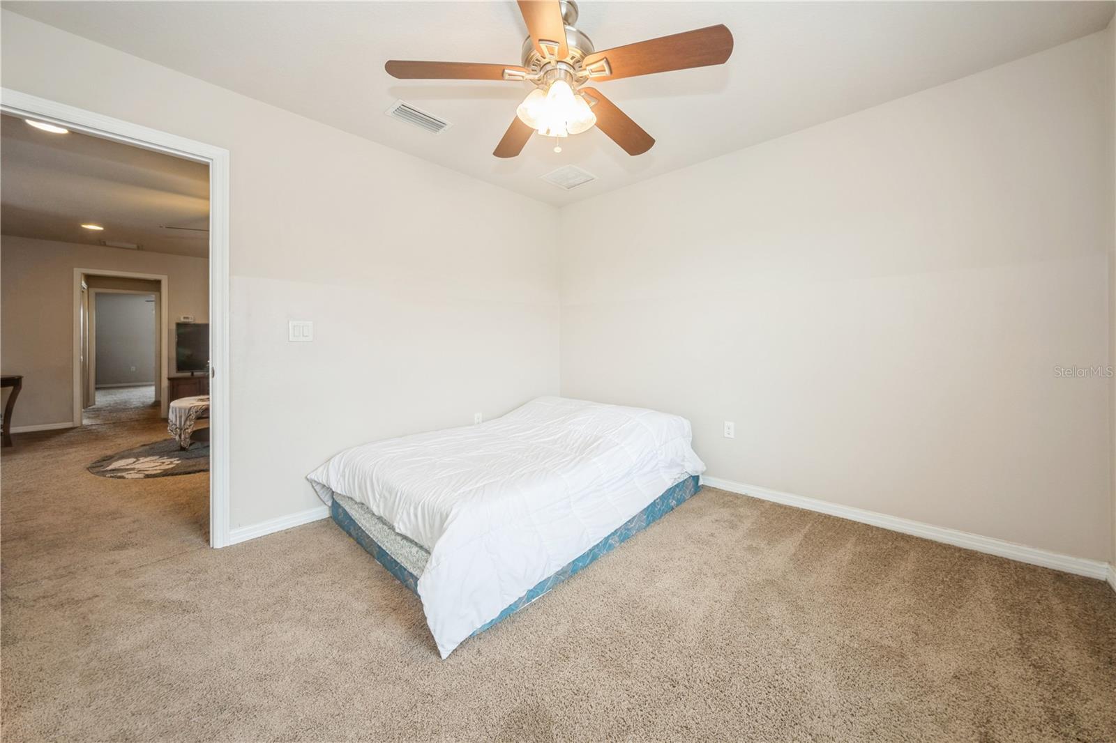 Guest bedroom with ceiling fan and closet space