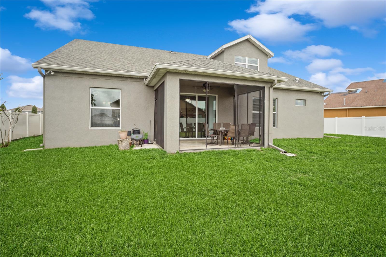 Rear view of home featuring covered patio and fenced-in yard, ideal for outdoor living.