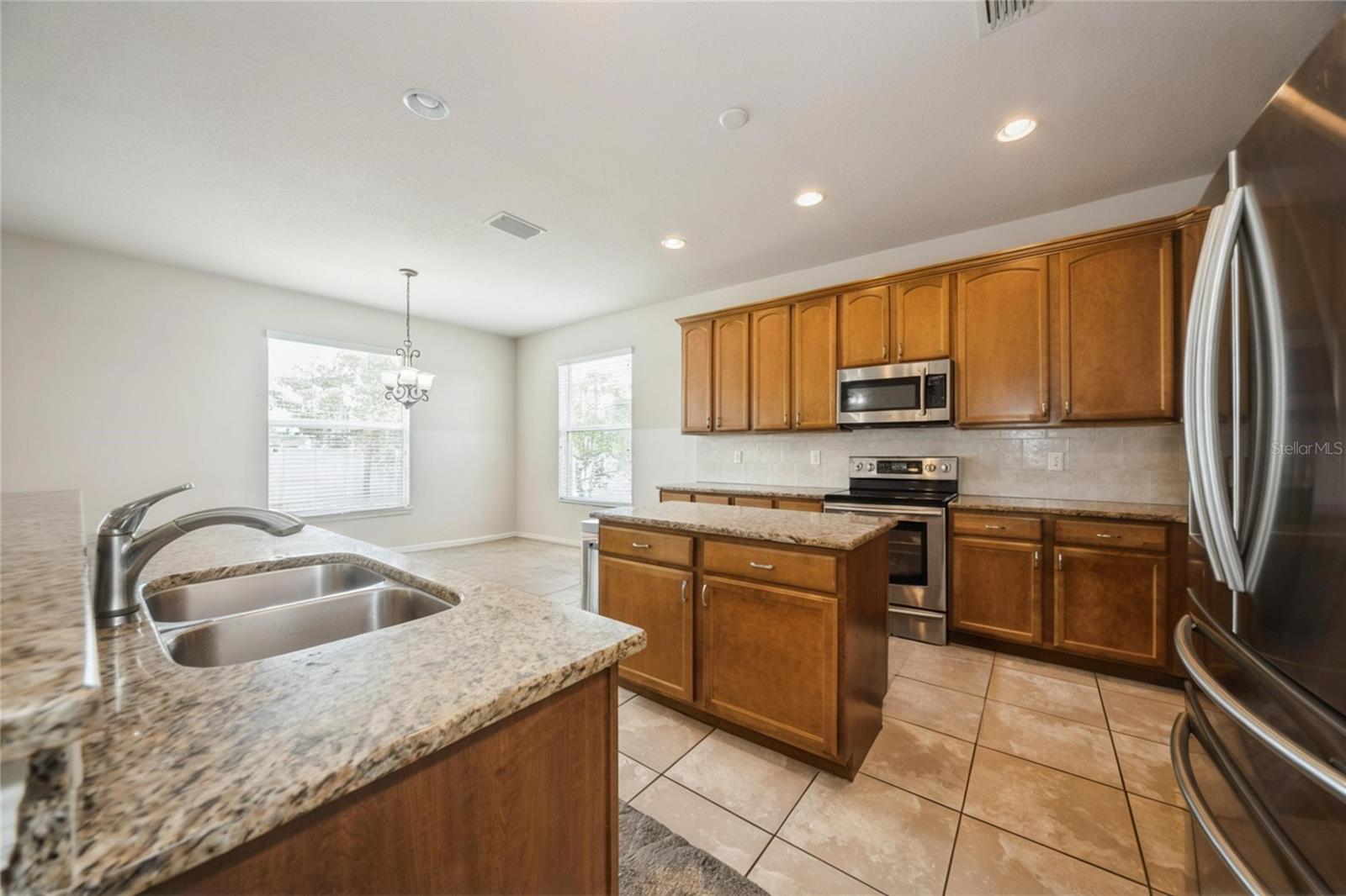Bright kitchen with breakfast bar and stainless steel appliances