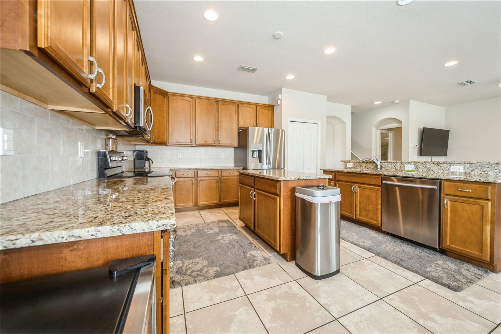 Granite counters, wood cabinetry, and large prep island