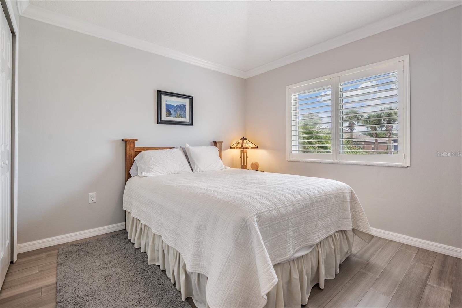 Light, bright Guest bedroom with plantation shutters and crown molding!