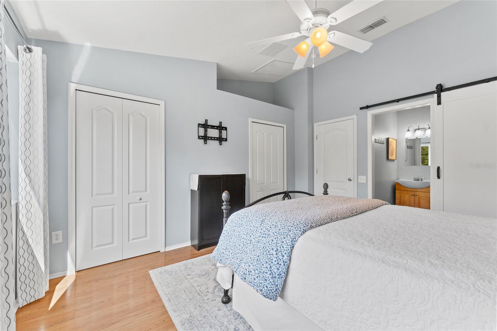 Primary bedroom has stylish and functional "barn door" to ensuite bath; tasteful decor