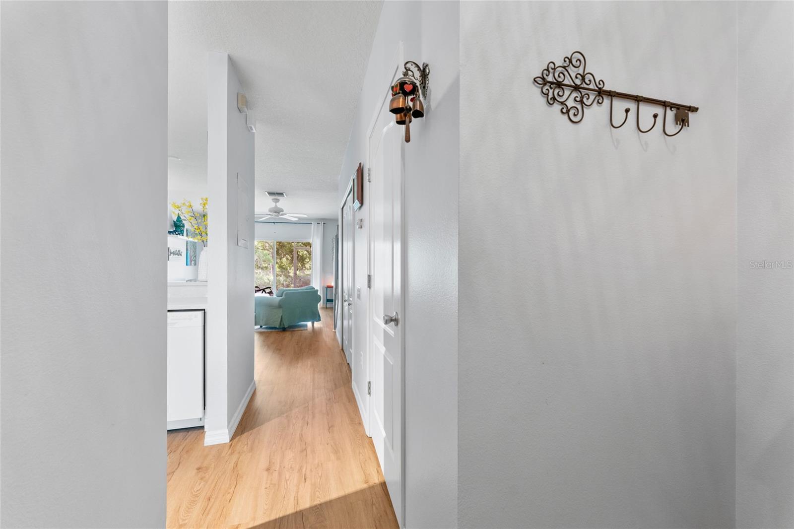 View from entry, 1st door on right is power room and 2nd door is laundry closet; Kitchen to left and living/dining beyond