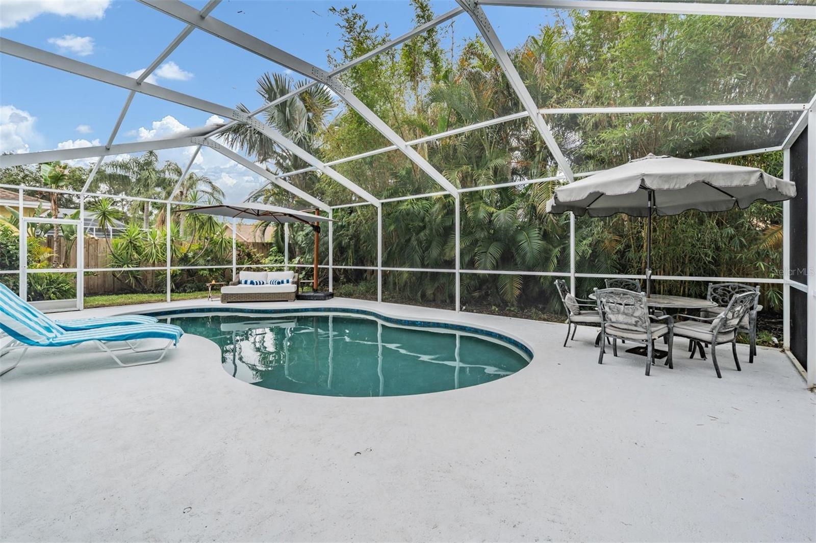 Huge Screened In Pool Deck with Lush Landscaping